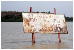 Sign in the River Gambia near Baboon Islands, reading "By order of Gambia P. Authority non-navigable channel."