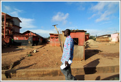 Man walking past orange houses.