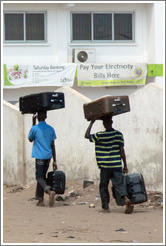 Men carrying suitcases on their heads.