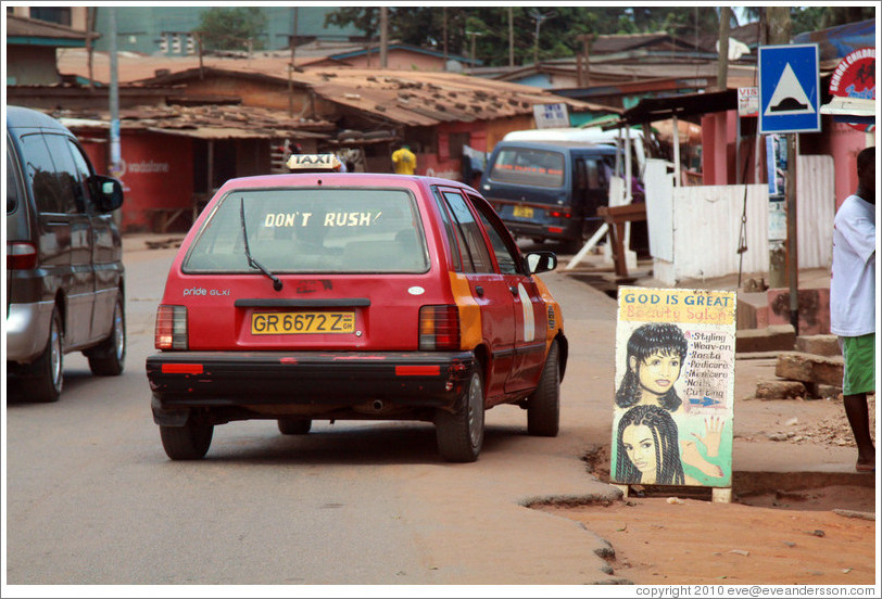 Taxi with Don't Rush sticker, and a sign for God is Great Beauty Salon.