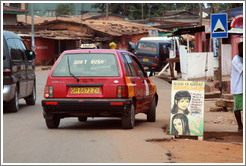 Taxi with Don't Rush sticker, and a sign for God is Great Beauty Salon.