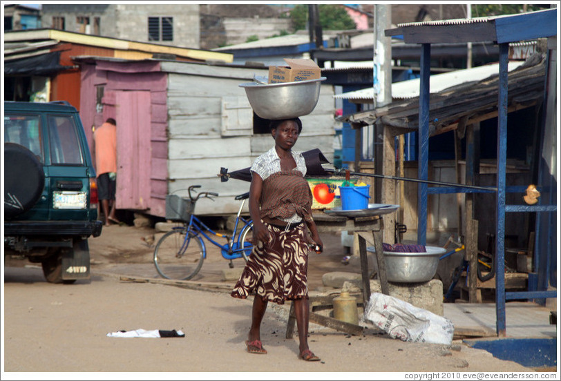 Woman balancing a bowl on her head.