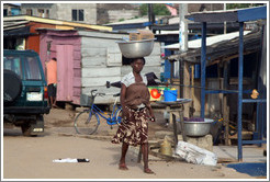 Woman balancing a bowl on her head.