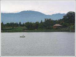 Canoeist in frunt of a lush, green backdrop.