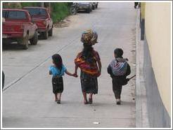 Woman balancing bag with two kids.