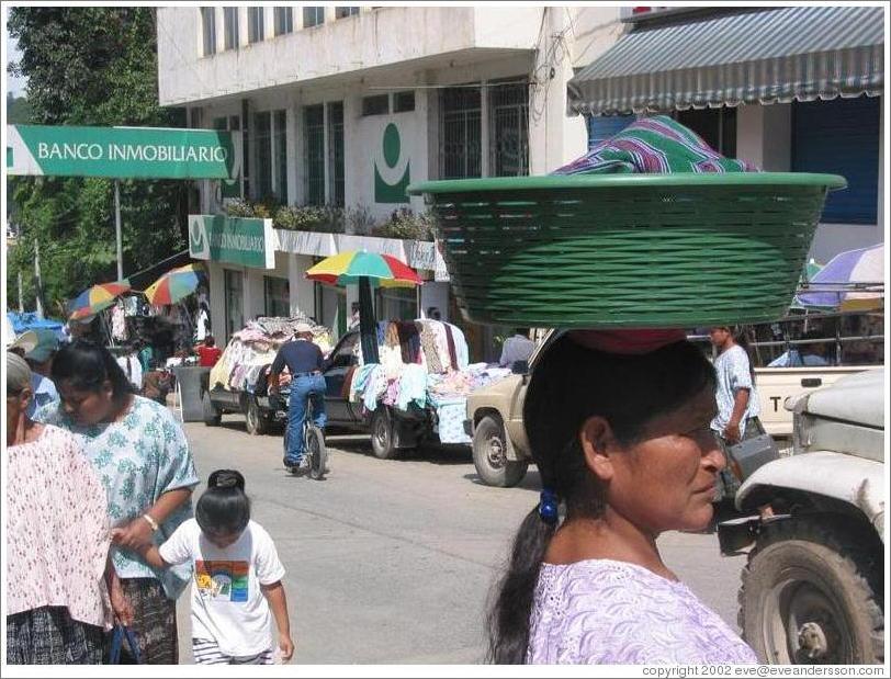 Woman carrying basket on head.