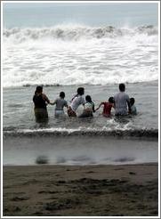 Monterrico beach.  Family enjoying the waves together.