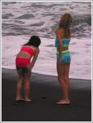 Two girls watching the baby turtles making their way to sea.