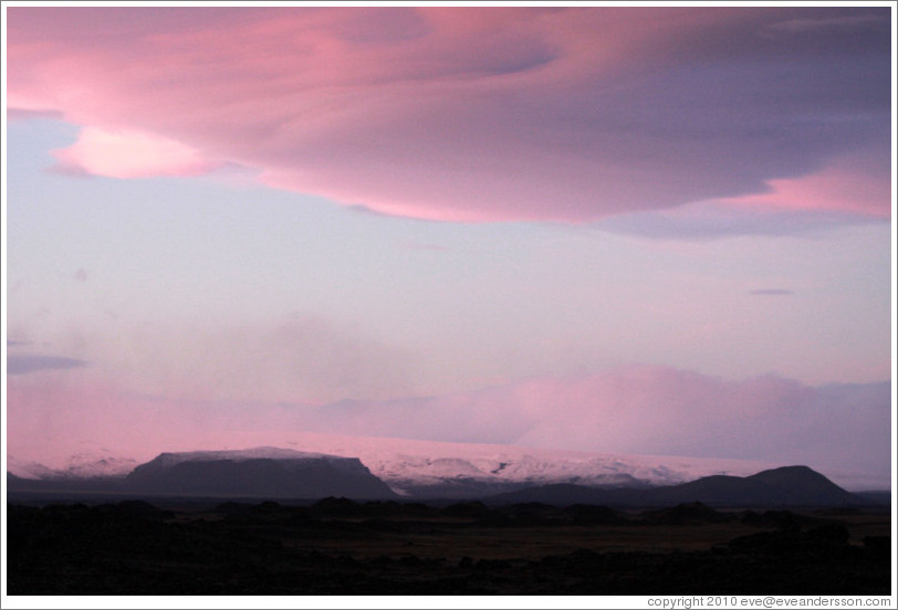 The glacier M?rdalsj?kull, appearing pink under a pink, dusky sky.