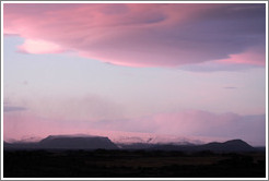 The glacier M?rdalsj?kull, appearing pink under a pink, dusky sky.