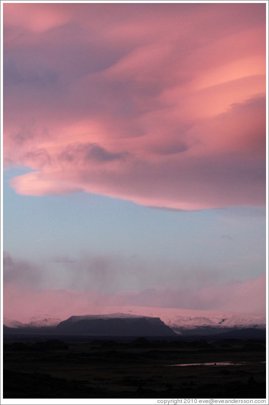 The glacier M?rdalsj?kull, appearing pink under a pink, dusky sky.