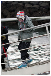 Child in Icelandic hat walking down ramp to boat.