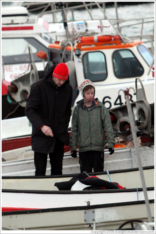 Father and child on boat in Reykjavik's harbor.