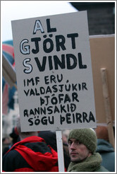 Protest in Reykjavik.  The sign says "Al gj?rt svindl IMF eru valdasj?kir ?j? rannsaki?gu ?eirra" ("Complete swindle; the IMF are power-greedy thieves, read up on their history").