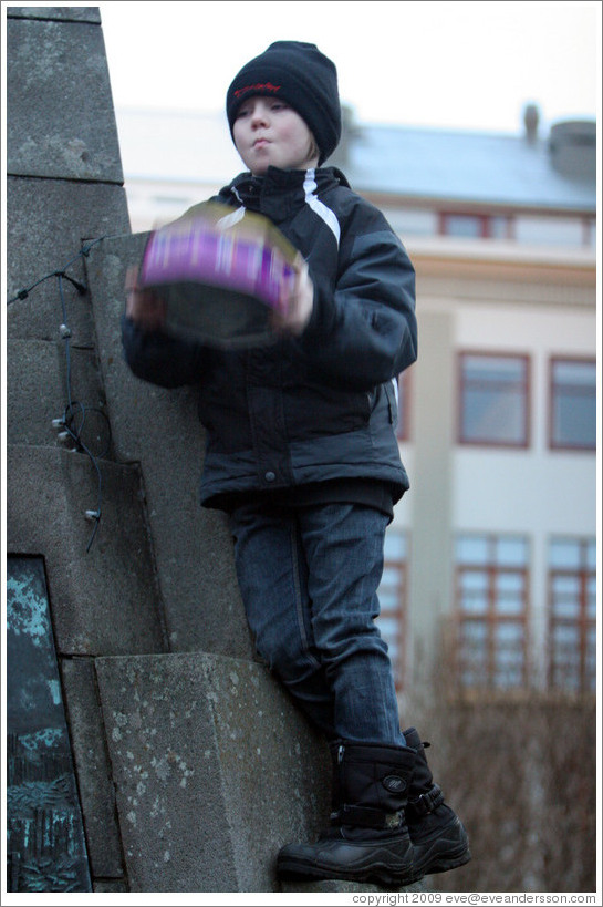 Reykjavik protest. Boy shaking tin.