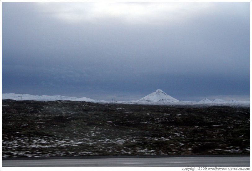 Volcanic terrain and snow-covered mountains.