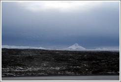 Volcanic terrain and snow-covered mountains.