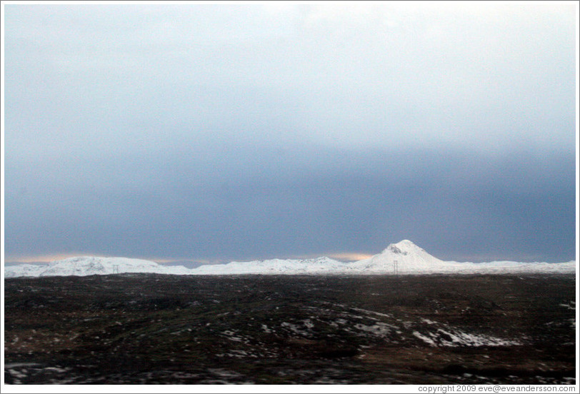 Volcanic terrain and snow-covered mountains.
