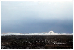 Volcanic terrain and snow-covered mountains.