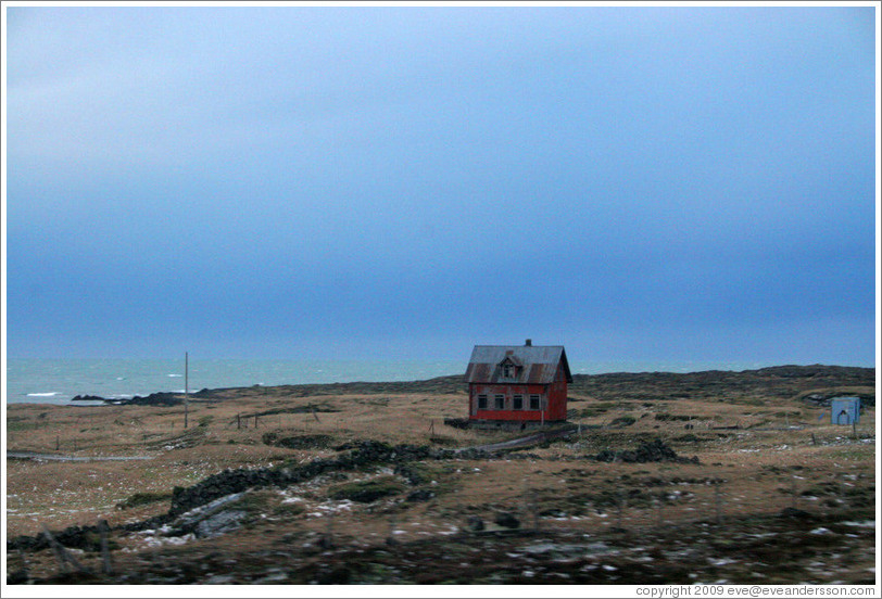 Red house on Iceland's volcanic coast.