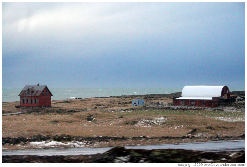 Red house and building on Iceland's volcanic coast.