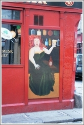 Painting of a fiery redhead enjoying the drink -- on a pub in Temple Bar, Dublin.