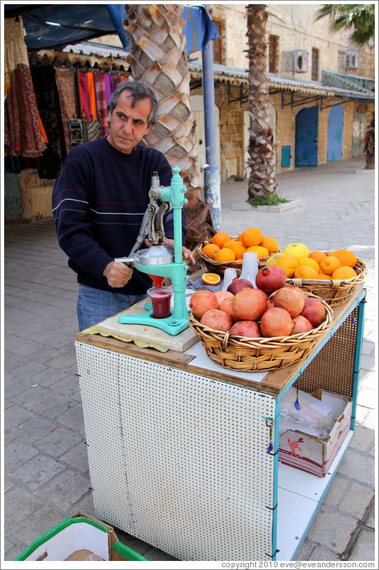 Man making pomegranate juice, old town Akko.