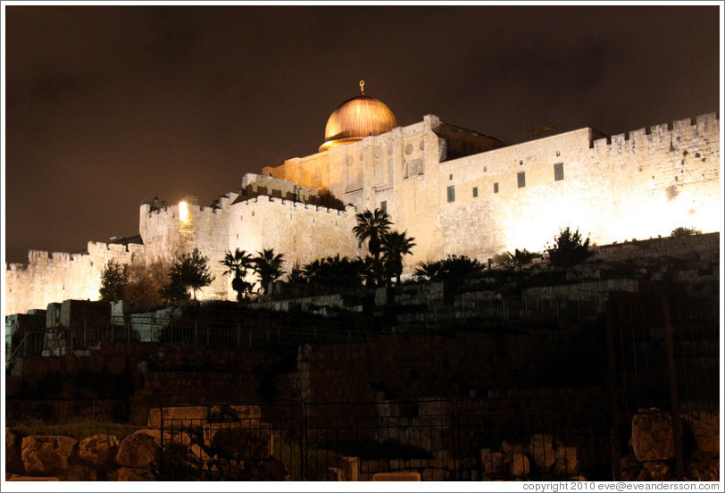 Night view of a dome and walls of the Old City of Jerusalem.