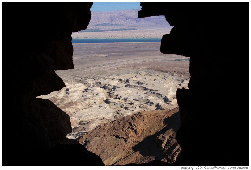 View of the desert and dead sea through a hole in the South Gate, desert fortress of Masada.