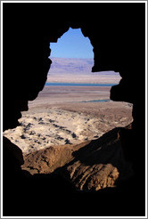View of the desert and dead sea through a hole in the South Gate, desert fortress of Masada.