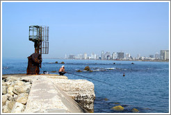 Man fishing, with Tel Aviv behind him.