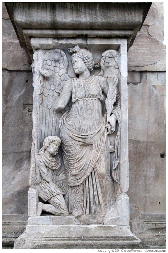 Slave kneeling before an angel.  Arco di Costantino (Arch of Constantine).