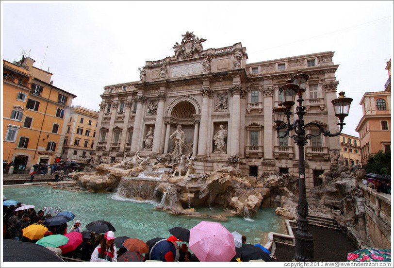 Fontana di Trevi (Trevi Fountain) on a rainy day, visited by an umbrella-toting crowd.