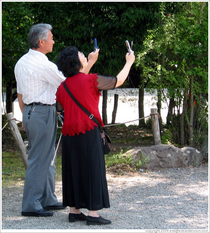 Couple photographing Masamune at Sendai Castle with their cellphones.