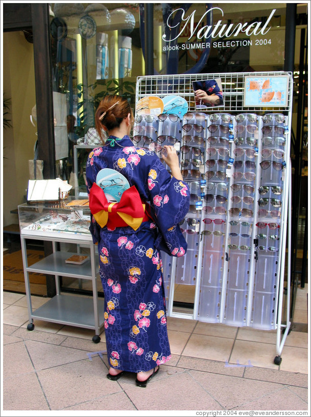 Girl wearing yukata looking at sunglasses.