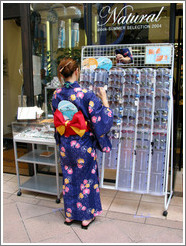 Girl wearing yukata looking at sunglasses.