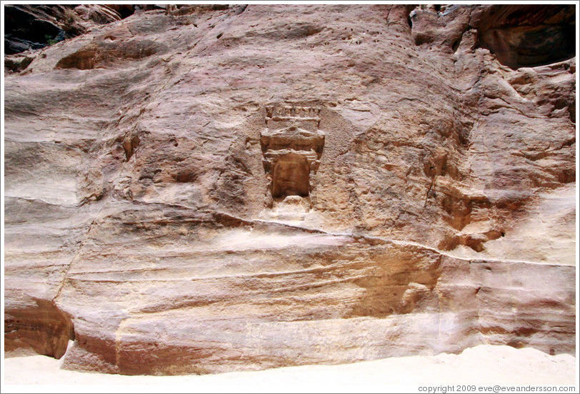 Stone wall with votive niche carved into it.