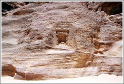 Stone wall with votive niche carved into it.