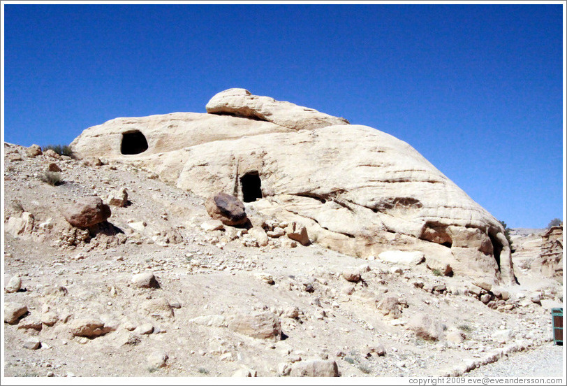 Large rock with three carved holes.