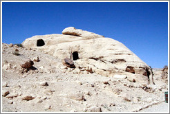 Large rock with three carved holes.