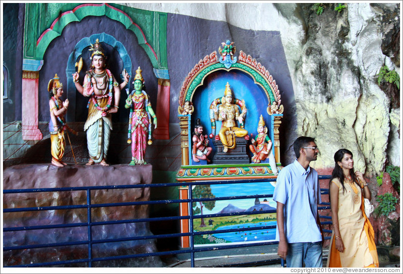 Two people in front of statues, Batu Caves.