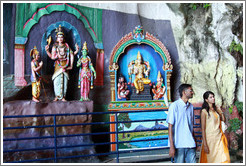 Two people in front of statues, Batu Caves.
