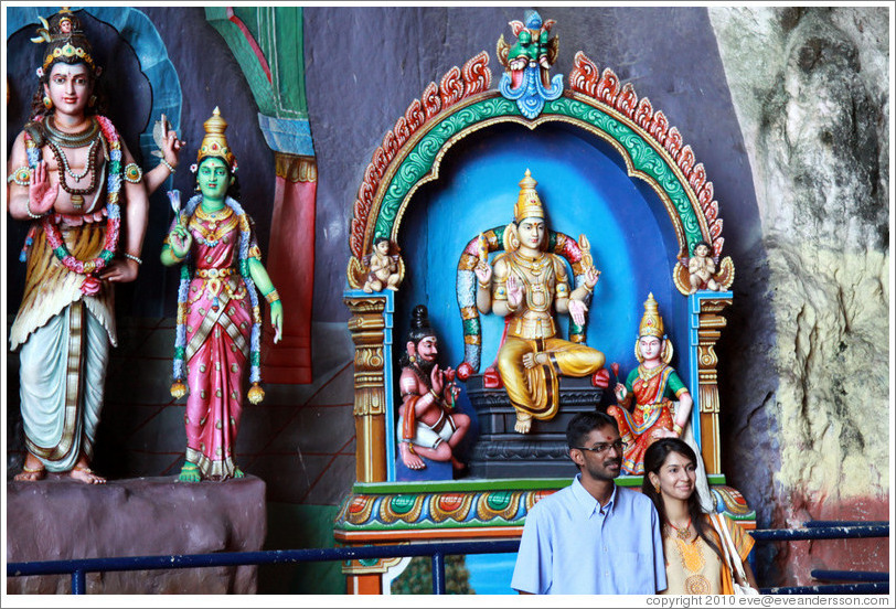 Two people in front of statues, Batu Caves.