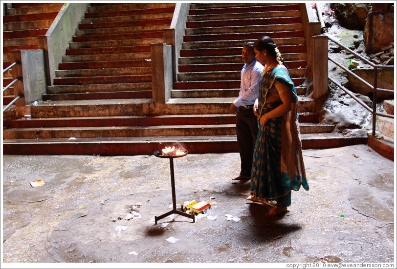 Man and woman in front of fire, Batu Caves.