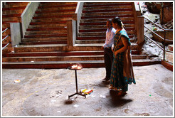 Man and woman in front of fire, Batu Caves.