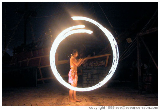 Girl with flaming balls on chains.