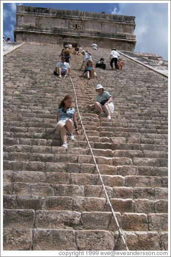 People sliding down on their butts from the pyramid.  Chichen Itza.