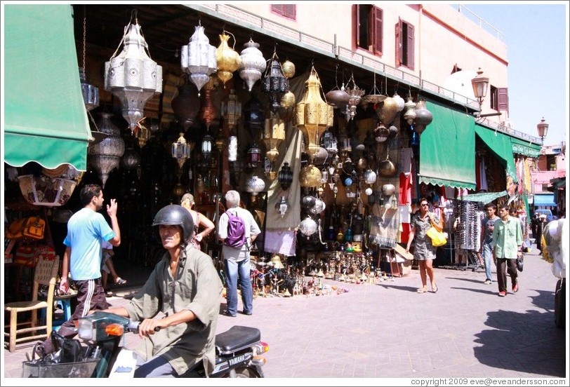 Man on a scooter in front of a lamp shop, Place Bab Fteuh.