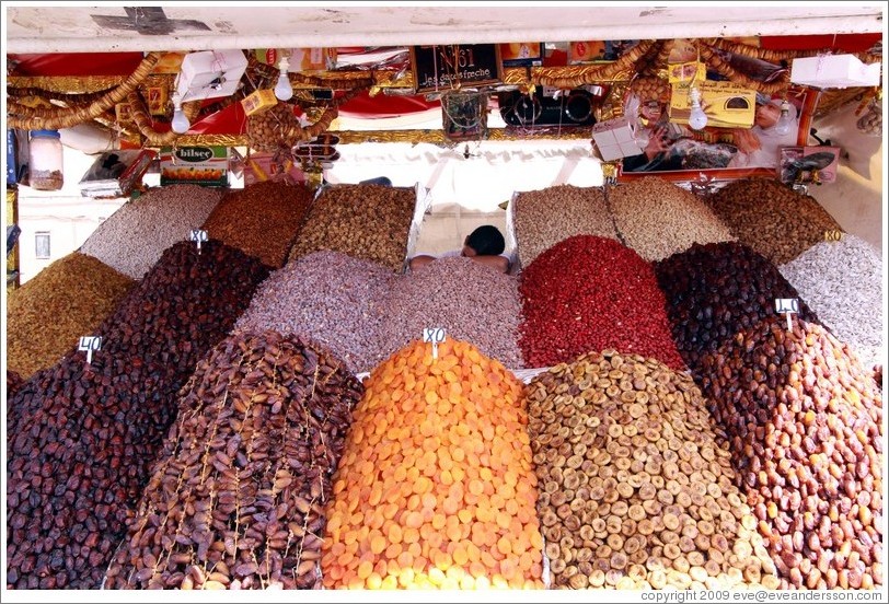 Boy asleep, manning a dried fruit stand in the midday heat, Jemaa el Fna.