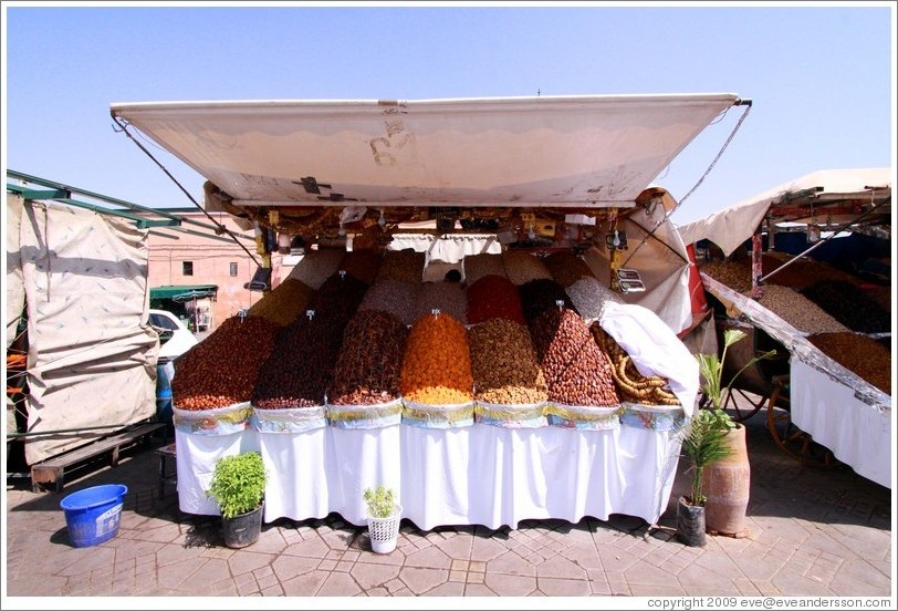 Boy asleep, manning a dried fruit stand in the midday heat, Jemaa el Fna.